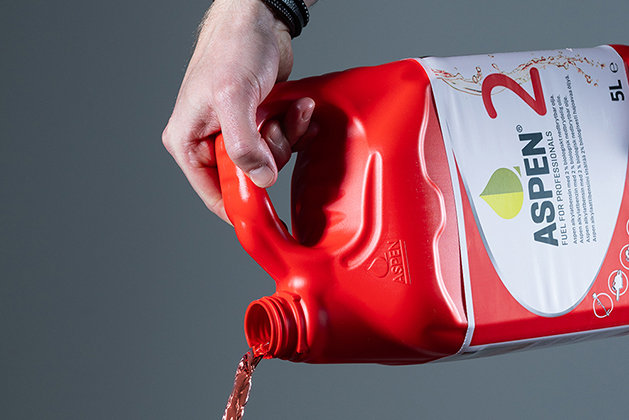 Röd bensin hälls ur röd plastdunk